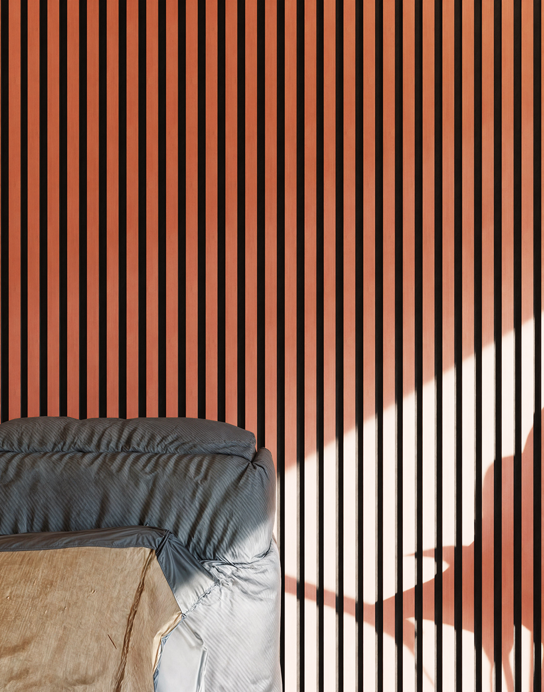 Akustikpaneel Classic - Coral Red (76) - 240x60 cm Coral Red Holz-Akustikpaneel DZ12 im Schlafzimmer mit vertikalen Lamellen und warmem Sonnenlicht