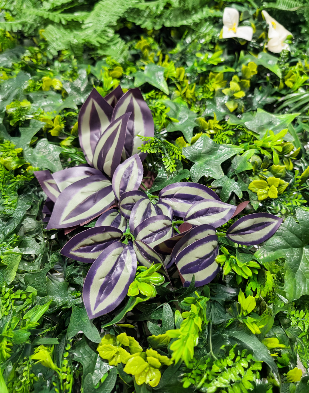 Pflanzenwand - Urban Bloom (266) - 50x100 cm Künstliche Pflanzenwand Urban Bloom mit lila-weißen Blättern und grünem Laub für Büro und Gastronomie