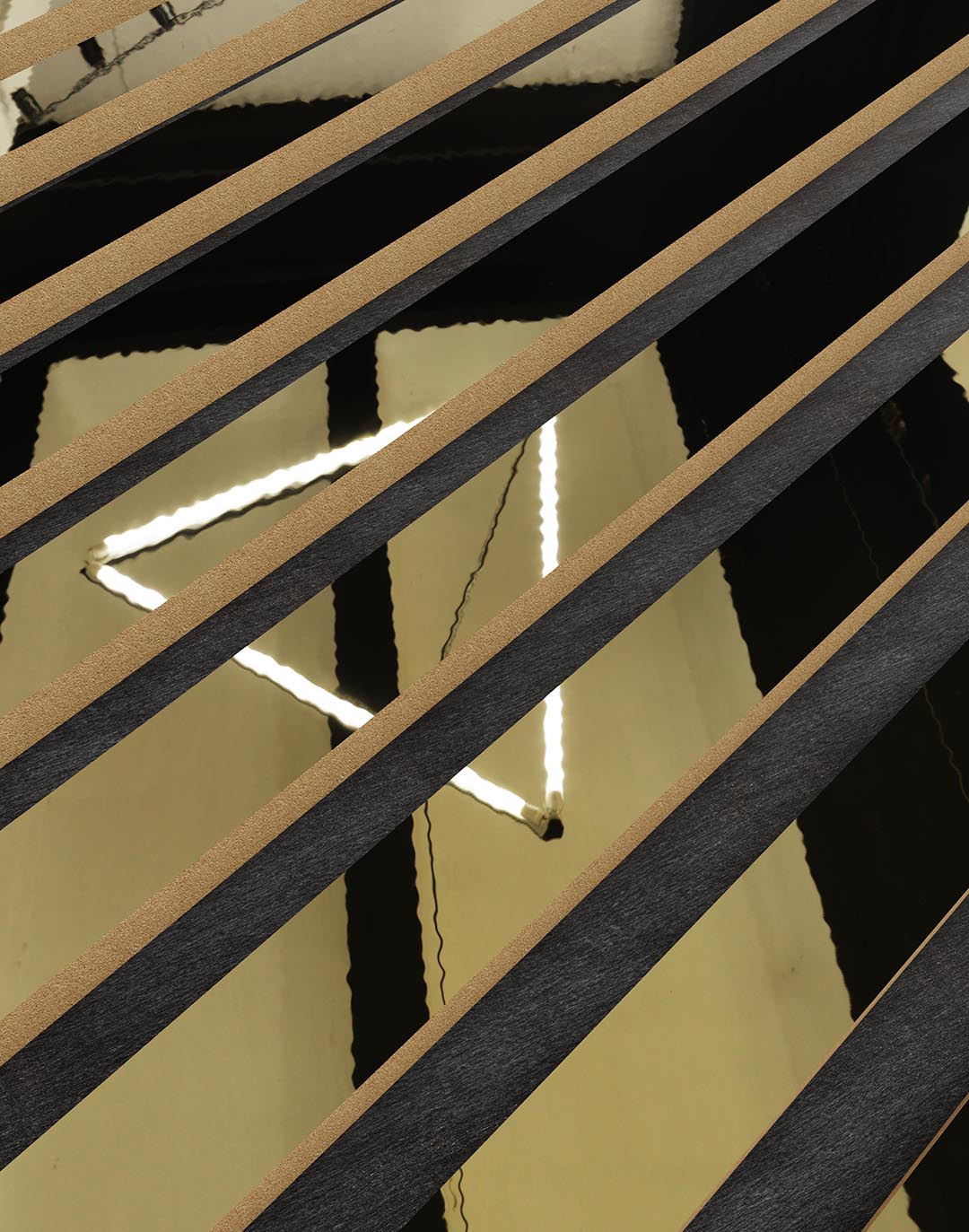 Akustikpaneel Classic - Mirror Gold (80) - 240x60 cm Akustikpaneel Mirror Gold Detailansicht schwarze Holzlamellen goldener Spiegelhintergrund modernes Wanddesign AKUSTIL