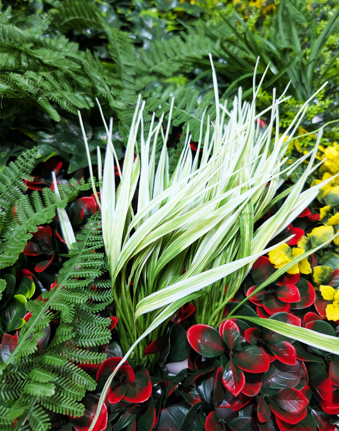 Pflanzenwand - Jungle Essence (258) - 100x100 cm Pflanzenwand AKUSTIL Jungle Essence mit grünen Farnen, weißen Gräsern und roten Blättern für Büro und Gastronomie